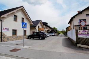 een auto geparkeerd op een parkeerplaats naast de huizen bij Domen's cozy rentals in Kranj