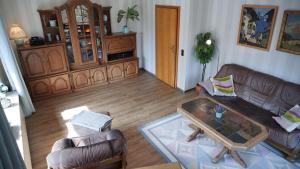 uma sala de estar com um sofá e uma mesa em Ferienwohnung Fuchsblick em Altenau