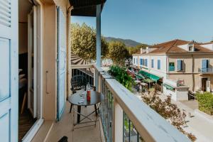 a balcony with a table and a view of a city at Hôtel L'Iroko The Originals City in Aix-les-Bains