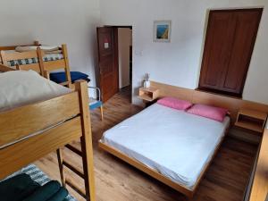 a bedroom with two bunk beds with pink pillows at Dom Klementa Juga in Lepena