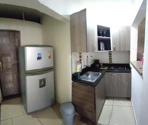 a small kitchen with a refrigerator and a sink at descanso in Medellín