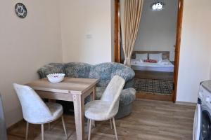- un salon avec une table, des chaises et un lit dans l'établissement JERUSALEM merkaz Hotel Kutaisi, à Koutaïssi