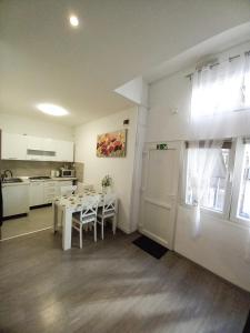 Apartment Centar في سلافونسكي برود: مطبخ وغرفة طعام مع طاولة وثلاجة