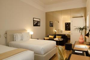 a hotel room with a bed and a living room at Elizabeth Unique Hotel | a Member of Design Hotels™ in Rome