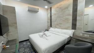 ein Schlafzimmer mit einem Bett und ein Badezimmer mit einem Waschbecken in der Unterkunft Mayilveedu Guest House in Thoothukudi