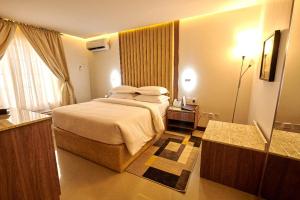 um quarto de hotel com uma cama e uma casa de banho em MEETHAQ HOTELS MAITAMA em Abuja