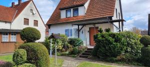 a white house with bushes in front of it at Haus am Park in Steinhagen