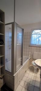 a bathroom with a tub and a toilet and a sink at Haus am Park in Steinhagen