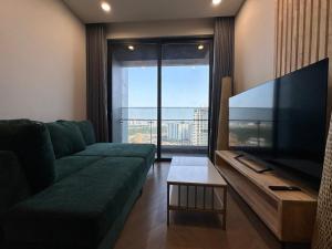 uma sala de estar com um sofá verde e uma grande televisão de ecrã plano em luxurious apartment close to city center em Ho Chi Minh