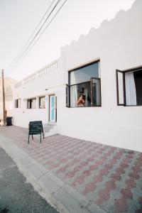 eine Bank, die vor einem weißen Gebäude sitzt in der Unterkunft Salaam Space in Muscat