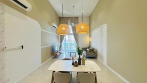 una sala da pranzo con tavolo e sedie bianchi di Quill Residence Suites @ DNE a Kuala Lumpur