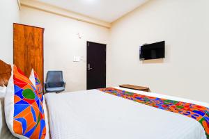 Cette chambre comprend un lit et une télévision. dans l'établissement FabExpress UV Residency, à Irugūr