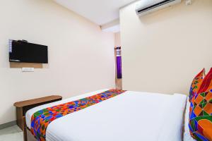 1 dormitorio con 1 cama con una manta colorida en FabExpress UV Residency en Irugūr