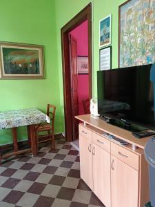 a living room with a flat screen tv and a table at Casa Colombini in Iglesias