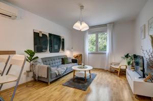 a living room with a couch and a table at Centar White Apartment in Pula