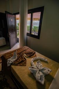 1 dormitorio con 1 cama con toallas en Sand Beach Resort, en Hurghada