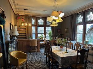 a dining room with a table and chairs and windows at The Regency in Ilfracombe