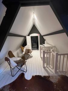 an attic room with two chairs and a couch at Hush Bed & Breakfast in Helmond