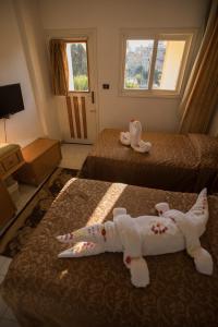 a hotel room with two beds with towel animals on them at Sand Beach Resort in Hurghada