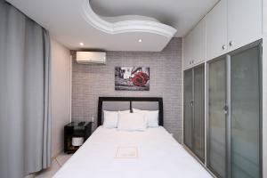 um quarto com uma cama branca num quarto em Casa Espaçosa com Jacuzzi e Churrasqueira RAU409 em Goiânia