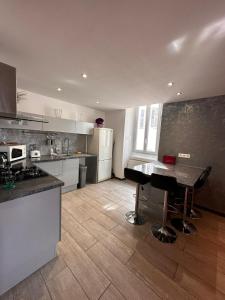 a kitchen with a table in the middle of it at La Charmerie, appartement duplex cosy 74m2 in Marseille