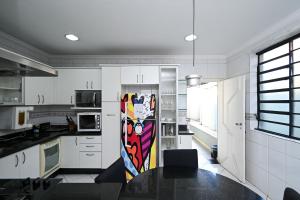 uma cozinha com uma mesa e um quadro na parede em Casa Espaçosa com Jacuzzi e Churrasqueira RAU409 em Goiânia