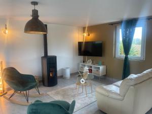 a living room with a couch and a fireplace at Gîte de campagne in Yvetot Bocage