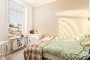 a small bedroom with a bed and a window at 56 Hawkhill Avenue in Ayr