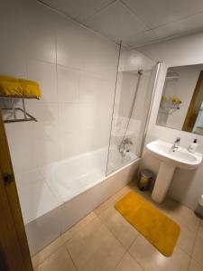 La salle de bains est pourvue d'une baignoire, d'un lavabo et d'une douche. dans l'établissement Casa Amarillo Mar Menor Golf Resort, à Murcie