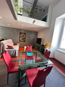 a living room with a glass table and red chairs at La Charmerie, appartement duplex cosy 74m2 in Marseille