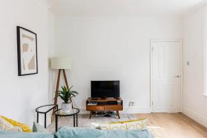 a living room with a couch and a tv at Stylish one bedroom apartment in Greater London in London