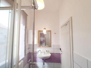 La salle de bains est pourvue d'un lavabo, d'un miroir et d'une douche. dans l'établissement Suite Balilla 6 centralissima a due passi dal mare, à San Benedetto del Tronto