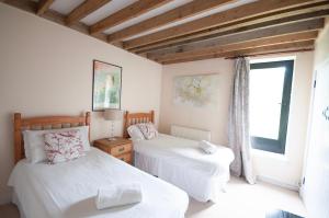a bedroom with two beds and a window at Corner Cottage in Shaftesbury