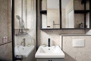 ein Bad mit einem Waschbecken, einem WC und einem Spiegel in der Unterkunft Home Away Apartments Stockholm in Stockholm