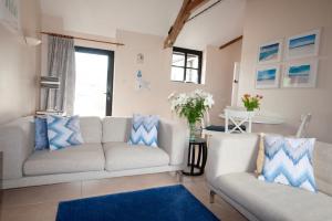 a living room with two couches and a table at Corner Cottage in Shaftesbury
