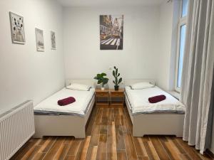 2 camas en una habitación con suelo de madera en Grand Place Apartement, en Bruselas