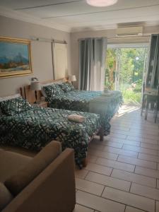 um quarto de hotel com duas camas e um sofá em B@home em Bloemfontein