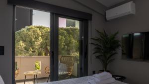 a bedroom with a bed and a sliding glass door at CHE BELLO NATURE in Preveza