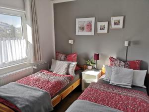 Un dormitorio con dos camas y una ventana. en diemelseeholiday Ferienwohnung am Diemelsee mit Balkon, en Diemelsee