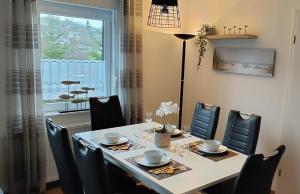 Un comedor con mesa y sillas y una ventana. en diemelseeholiday Ferienwohnung am Diemelsee mit Balkon, en Diemelsee 17 fotos más