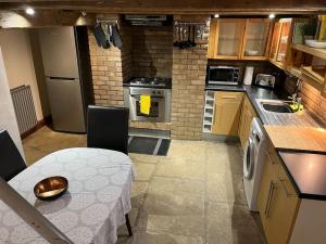 a small kitchen with a table and a sink at Steeple View - A two bedroom 18th century cottage. in Leeds