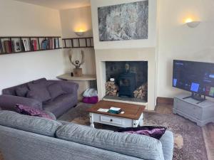 a living room with a couch and a fireplace at Steeple View - A two bedroom 18th century cottage. in Leeds