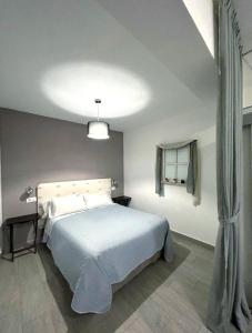 una camera da letto con un letto con copriletto bianco di Loft CENTRO Con parking GRATIS y Azotea CHILLOUT GRATIS! a Talavera de la Reina