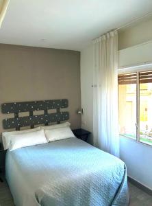 a bedroom with a large bed and a window at Loft CENTRO Con parking GRATIS y Azotea CHILLOUT GRATIS! in Talavera de la Reina