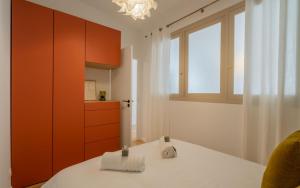 une cuisine avec des armoires orange et une table blanche dans l'établissement Chez So à 2 minutes du Vieux-Port by Weekome, à Marseille