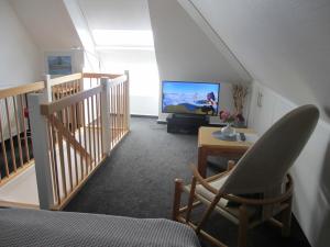ein Wohnzimmer mit einer Treppe und einem TV in der Unterkunft Meerblick 15 - Großenbrode in Großenbrode