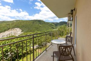 a balcony with a table and chairs and mountains at Vila Lavandel in Bečići