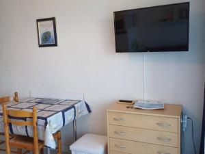 1 dormitorio con tocador y TV en la pared en Appartement Balaruc-les-Bains, 1 pièce, 2 personnes - FR-1-571-24 en Balaruc-les-Bains