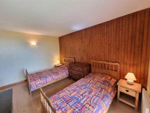 two beds in a bedroom with wood paneled walls at Appartement Saint-Michel-de-Chaillol, 3 pièces, 4 personnes - FR-1-393-139 in Saint-Michel-de-Chaillol