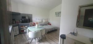 een kleine kamer met een bed en een tafel en stoelen bij Chez Dom & Albert in Saint-Cézaire-sur-Siagne